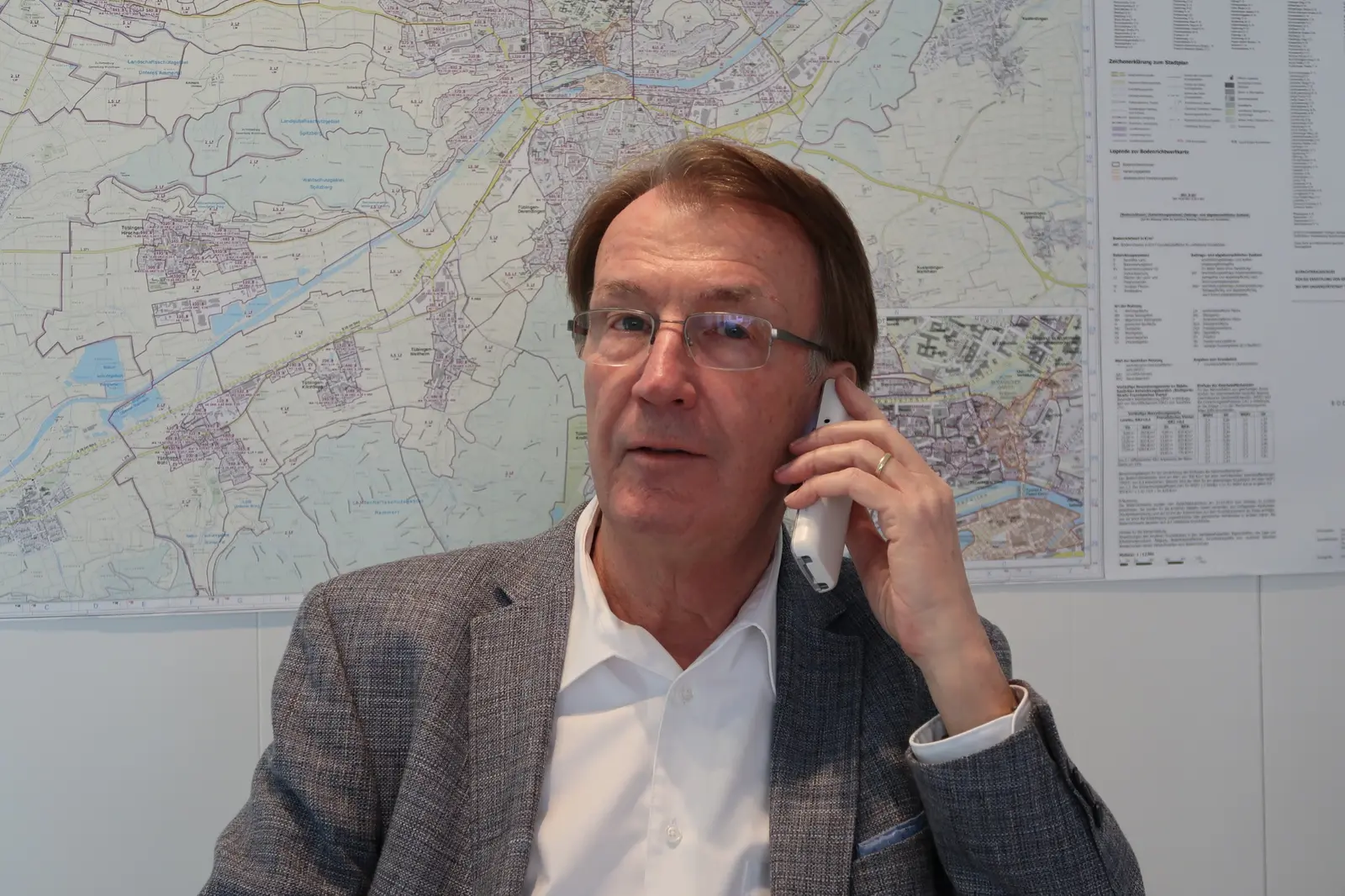 Otto Springmann vor einer Stadtkarte von Tübingen